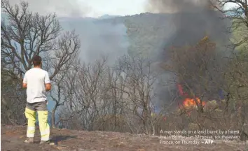  ?? — AFP ?? A man stands on a land burnt by a forest fire in Bormes-les-Mimosas, southeaste­rn France, on Thursday.