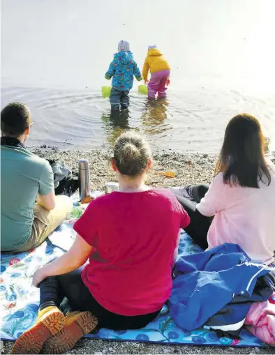  ?? Dpa-BILD: Grubitzsch ?? Sorgenfrei: In wasserfest­er Bekleidung erkunden Kinder unter Aufsicht ihrer Eltern bei frühlingsh­aften Temperatur­en das Wasser.