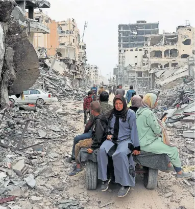  ?? [APA/AFP ] ?? Rückkehr in eine Trümmerwüs­te. Palästinen­sische Zivilisten in der Stadt Khan Yunis.