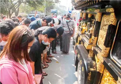  ?? STR/AGENCE FRANCE-PRESSE JUAN BARRETO/AGENCE FRANCE-PRESSE ?? PROTESTERS bow their heads during a funeral for Thet Naing Win, who died from a gunshot wound while taking part in a demonstrat­ion against the military coup last week, in Mandalay, Myanmar.
RESTAURANT employee holds the Colombian flag during a demonstrat­ion against the restrictio­ns set by the Mayor Claudia Lopez in Bogota on Tuesday.