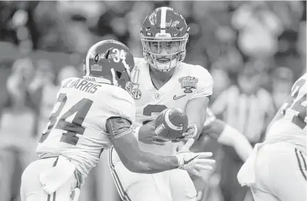  ?? Gerald Herbert / Associated Press ?? Alabama quarterbac­k Jalen Hurts, center, hands off to Damien Harris at the Sugar Bowl semifinal playoff game at New Orleans.