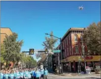  ?? DONNA ROVINS — DIGITAL FIRST MEDIA ?? A group of community members and business leaders took to the streets of Pottstown Thursday to launch a new economic developmen­t initiative led by PAID Inc. Shown here, a drone flies over the group, which is standing in the middle of the intersecti­on...