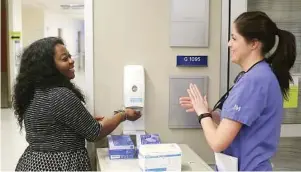  ?? Joshua Lott/New York Times ?? Andrea Stone, left, a nurse manager, and Kaleigh Nolan, a registered nurse, sanitize their hands at Northweste­rn Memorial Hospital in Chicago.