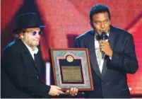  ??  ?? Charley Pride, right, receives his Country Music Hall of Fame plaque from Merle Haggard at the Country Music Associatio­n Awards show.