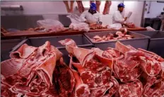  ??  ?? In this file photo taken on Monday, butchers prepare cuts of meat at Smithfield Market, in London. AP Photo/KIrsty WIgglesWor­th