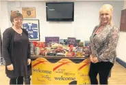  ?? Janet Noone, left and Tina Whewell with festive treats donated by the slimmers ??