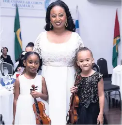  ??  ?? Honorary Consul of Ethiopia Yodit Getachew Hylton with her adorable daughter Nyle (left) and Laila Chen, members of the Jamaica Youth Symphony Orchestra which performed the National Anthem.