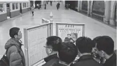  ?? ED JONES/AFP/ GETTY IMAGES ?? Commuters read statecontr­olled newspapers at a subway station in Pyongyang, North Korea, but are told little of the upcoming summit.