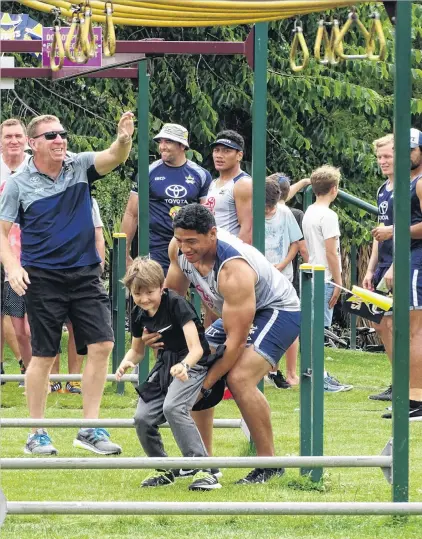  ?? PHOTO: TRACEY ROXBURGH ?? League of their own . . . Cowboys lock and 2016 joint Dally M Medal winner Jason Taumalolo helps Arrowtown School pupil Riley Jensen (11) navigate an obstacle course at the school yesterday while Cowboys general manager Peter Parr watches.