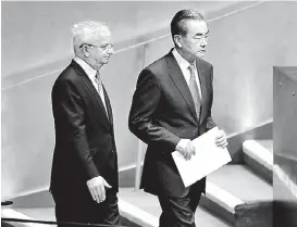  ?? CARLO ALLEGRI/REUTERS ?? El canciller chino, Wang Yi, es acompañado antes de su discurso.