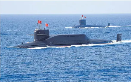  ?? REUTERS ?? Nuclear-powered Type 094A Jin-class ballistic missile submarines of the Chinese People’s Liberation Army Navy in the South China Sea in April 2018. Facing the three Aukus powers — Australia, the UK and the US — China is projected to enhance its maritime capabiliti­es.