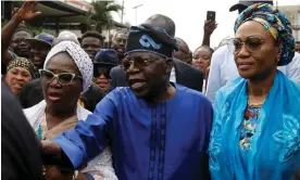  ?? Photograph: Akintunde Akinleye/EPA ?? Bola Tinubu (centre) makes his way through the crowd after casting his vote in Lagos on Saturday.