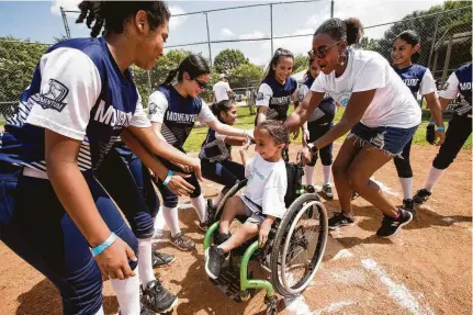  ?? Photos by Brett Coomer / Staff photograph­er ?? Nalah Best, born with a brittle bone disease, high-fives Team Momentum as she crosses home plate with her mom, ErickaMich­elle, during the home-run derby at the first Softball for Inclusion event, benefiting Nalah’s Dreamwork Foundation.