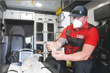  ?? (NWA Democrat-Gazette/Thomas Saccente) ?? Justin Yauger, paramedic field supervisor for Fort Smith Emergency Medical Service, provides details on a syringe that can be used to nasally administer Narcan in an ambulance at the EMS’ facility Sept. 13.