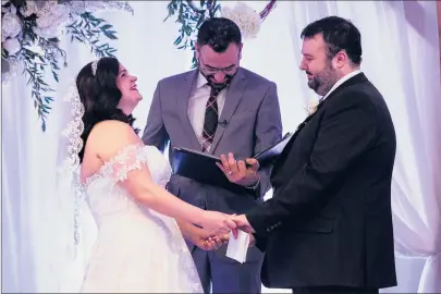  ?? KASSI JACKSON/HARTFORD COURANT PHOTOS ?? Alyssa Griffin and Jonathan Sales hold hands while laughing at remarks made by their justice of the peace, John Norko, who is also a physician in the hematology/oncology department at the hospital, during their wedding at Connecticu­t Children’s on Saturday.