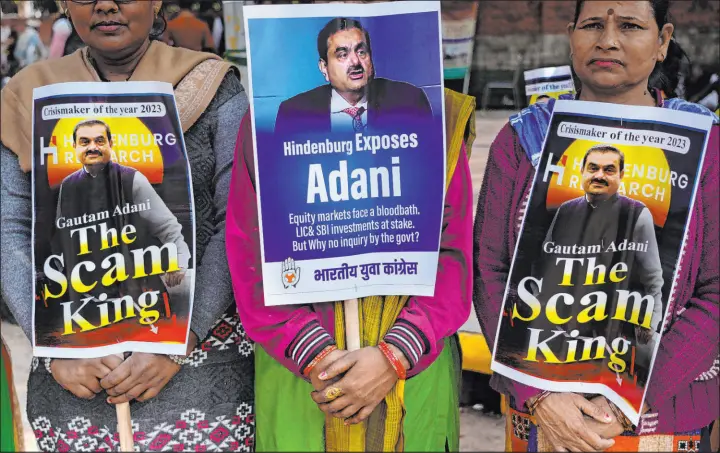  ?? Manish Swarup The Associated Press ?? Members of the opposition Congress party hold placards with images of Indian businessma­n Gautam Adani of the Adani Group during a protest in New Delhi, India, on Monday.