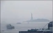  ?? JULIE JACOBSON — THE ASSOCIATED PRESS ?? The Staten Island Ferry departs from the Manhattan terminal in New York through a haze of smoke with the Statue of Liberty barely visible.