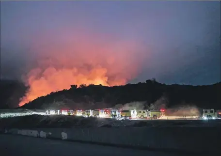  ?? Robert Gauthier Los Angeles Times ?? FIRE ENGINES head to the f laming Santa Anita Canyon as the Bobcat blaze, which ignited Sept. 6, burns Sunday night near Arcadia.