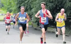  ??  ?? He’s behind you Colin Williams (140) of Moorfoot Runners checks back as Shettlesto­n Harriers runner Denis Williams closes in