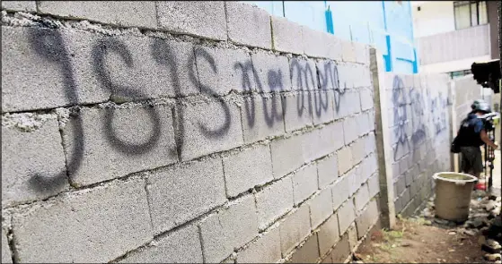  ?? REUTERS ?? Graffiti is seen on a wall of a back alley near houses cleared of Maute fighters by government forces amid continuous air and ground assaults on positions of the terror group in Marawi City yesterday.