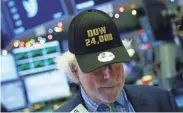  ??  ?? A trader on the NYSE celebrates Dow 24K on Nov. 30, the day the Dow closed above that mark for the first time. DREW ANGERER/GETTY IMAGES