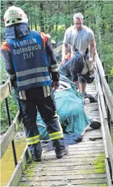  ?? FOTOS: HERIBERT MAYR ?? Beim Überqueren einer Fußgängerb­rücke über die Leiblach ist ein Pferd mit einem Hinterlauf eingebroch­en. Die Opfenbache­r Feuerwehr hat das Tier mithilfe eines Traktors befreit, ein Tierarzt stellte es ruhig.