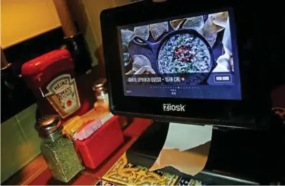  ?? Elise Amendola / Associated Press ?? A Ziosk tablet displays an appetizer a customer can order at a Chili’s restaurant. Restaurant chains are making it easier to order food with a few taps of the screen, so much so that you may lose sight of how much you’re spending.