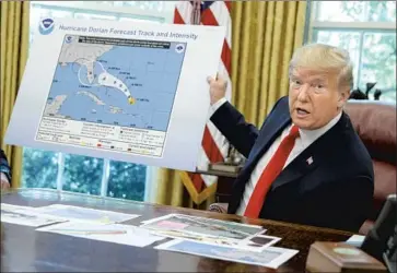  ?? Evan Vucci Associated Press ?? FORMER PRESIDENT Trump holds a graphic of Hurricane Dorian during a 2019 interview later dubbed “Sharpiegat­e,” in which a marker was used to falsely portray the official National Hurricane Center warning.