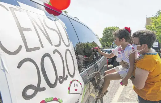  ?? TYLER LARIVIERE ?? Fernanda, izquierda, con la ayuda de Margarita Marquez decora su vehículo que manejarán en la caravana por La Villita para promover el censo.