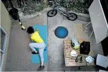  ?? —PHOTOS FROM AP ?? RIDING HIGH ON HOPE Venezuelan Olympic medalist Stefany Hernández, a BMX racing cyclist, rides across an empty Bolivar Avenue amid the COVID19 pandemic in Caracas, Venezuela (top photo). Before taking the streets, Hernández warms up by stretching at her home.