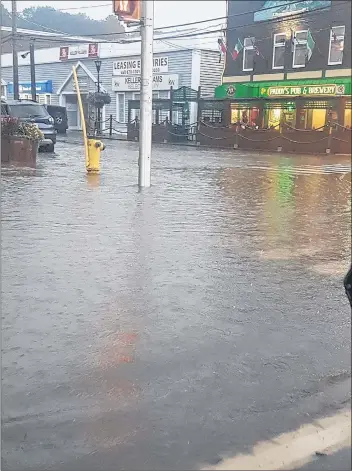  ?? SHELLEY CORCORAN ?? Streets in downtown Kentville temporaril­y flooded during a heavy downpour that occurred in the evening Aug. 4.