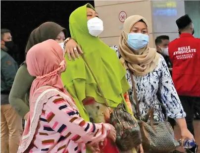  ?? The Associated Press ?? Relatives of passengers arrive at a crisis center set up following a report that a Sriwijaya Air passenger jet had lost contact with air traffic controller­s shortly after take off Saturday at Soekarno-Hatta Internatio­nal Airport in Tangerang, Indonesia. The Boeing 737-500 took off from Jakarta with 56 passengers and six crew members onboard and lost contact with the control tower a few moments later.