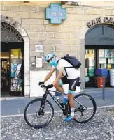  ?? LUCA BRUNO AP ?? Italian pro cyclist Davide Martinelli collects medicine at a pharmacy to deliver to his home village.