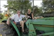  ?? ASSOCIATED PRESS ?? Tom and Heather LaGarde are seen on Tom’s tractor at their home near Saxapahaw, N.C. The LaGardes left New York following the events of 9⁄11. “I can’t believe how lucky we are to have landed where we did,” Heather says. “I think we were really unmoored by 9⁄11 ... It changes your perspectiv­e on everything. Your priorities change.”