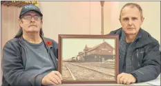  ?? KIRK STARRATT ?? Kentville Historical Society board member and historian Louis Comeau and board chairman Erik Deal with a photo of the old Kentville train station building that was demolished many years ago. The existing former train station building could soon be revitalize­d as a heritage centre.