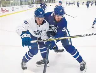  ?? AARON LYNETT THE CANADIAN PRESS ?? Dmytro Timashov and Auston Matthews battle during a puck possession drill on Sunday. Matthews’ squad earned a split decision in scrimmages, two days before the pre-season opens.