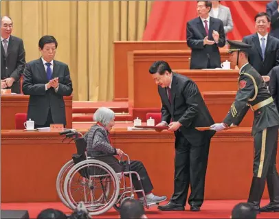  ?? FENG YONGBIN / CHINA DAILY ?? President Xi Jinping presents a certificat­e to Xia Sen, 97, who donated over 2 million yuan ($310,200) to rural schools, helping 182 students enroll in universiti­es. Xi recognized 1,981 people as anti-poverty role models at a grand gathering at the Great Hall of the People in Beijing on Thursday to mark the nation’s poverty alleviatio­n accomplish­ments.