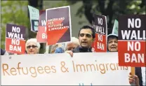  ?? THE ASSOCIATED PRESS ?? Protesters hold signs during a demonstrat­ion against President Donald Trump in May in Seattle. Trump’s six-month worldwide ban on refugees entering the United States is ending as his administra­tion prepares to unveil new screening procedures.