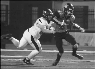  ?? Photo by Alexis Meeks ?? Malvern’s Carter Martin tries to escape a tackle against a Trumann defender Friday. Martin had three catches for 69 yards and two touchdowns against Trumann.