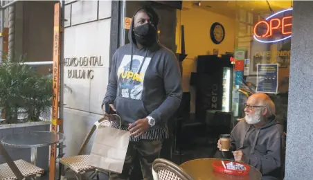  ?? Paul Chinn / The Chronicle ?? Gleyson Coelho, a DoorDash delivery driver, called Dashers by the company, picks up an order at Cafe Encore in San Francisco.