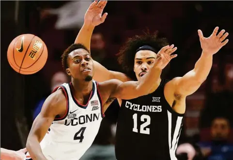  ?? Rick Bowmer / AP ?? UConn guard Nahiem Alleyne (4) and Iowa State forward Robert Jones watch the ball during the first half in the championsh­ip of the Phil Knight Invitation­al on Sunday in Portland, Ore.