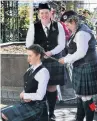  ??  ?? Ashburton Pipe Band Lauren Wright (26) has her hair braided by fellow band members Jennifer Martin (left) and Samantha Doak.