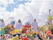  ?? DAVID SANTIAGO/MIAMI HERALD ?? People dressed in angel costumes stand by a makeshift memorial outside Marjory Stoneman Douglas High School in Parkland, Fla., on Sunday.