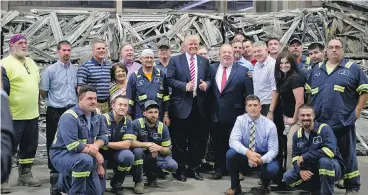  ?? JEFF SWENSEN / GETTY IMAGES ?? Then-Republican presidenti­al candidate Donald Trump gathers with workers in Monessen, Penn., last June. Nearly 1,000 Democrats in the town switched sides in the election and voted for Trump.