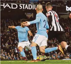  ?? REUTERS PIC ?? Manchester City's Sergio Aguero scores their third goal to complete his hat-trick against Newcastle in a Premier League match at Etihad Stadium on Saturday.