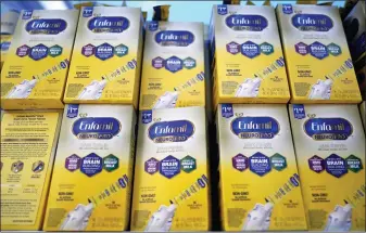  ?? DAVID J. PHILLIP — ASSOCIATED PRESS FILE PHOTO ?? FILE - Infant formula is stacked on a table during a baby formula drive to help with the shortage May 14, 2022, in Houston. President Joe Biden has invoked the Defense Production Act to speed production of infant formula and has authorized flights to import supply from overseas.