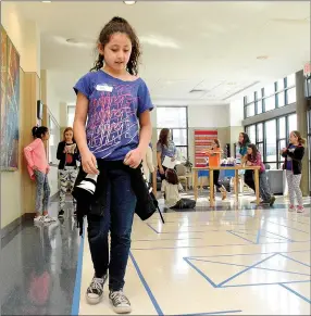  ?? Janelle Jessen/Herald-Leader ?? Addy Carreno walked through a maze on the floor guided by programmin­g from her team to simulate how computer programmin­g guides a computer’s actions during the Introduce a Girl to Engineerin­g Day workshop at John Brown University on Saturday morning.