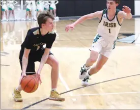  ?? Alex Eller ?? Jeffery Cunningham of Ansley-Litchfield loooks to pass the ball inside while a North Platte St. Patrick’s defender trails on March 10. He finished with 15 points and made three three-pointers vs the Irish.