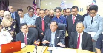  ??  ?? Jaujan (seated second right) speaking to the media after chairing the Semporna district’s developmen­t action committee meeting yesterday.