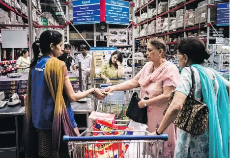  ?? SANJIT DAS/BLOOMBERG FILES ?? A customer pays at a checkout counter at a Walmart store in Zirakpur, on the outskirts of Chandigarh, India. Walmart is drasticall­y redrawing its retail map, turning its focus on high-potential markets like China and India and finding partners to help...
